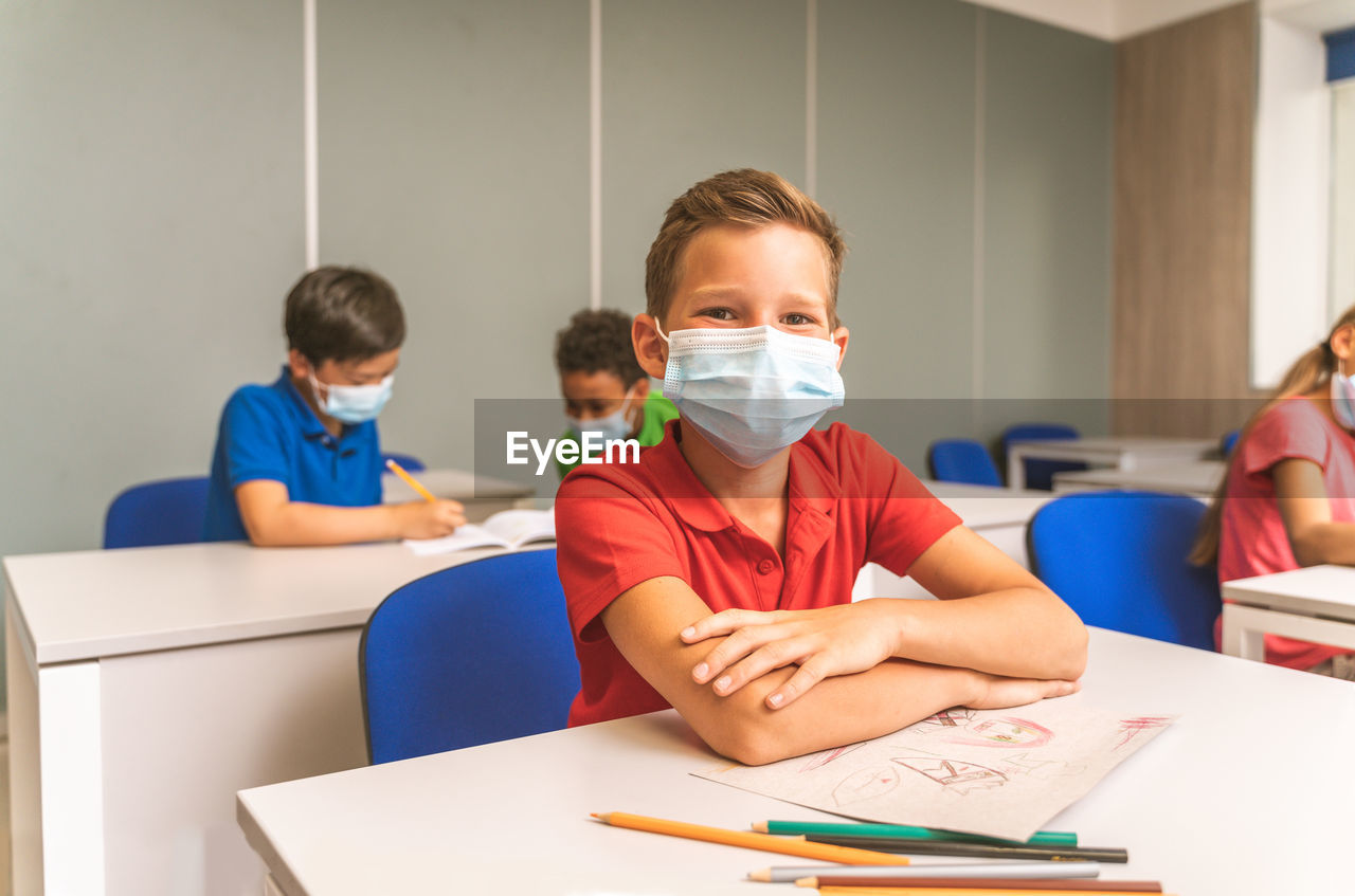 Portrait of smiling boy sitting at classroom