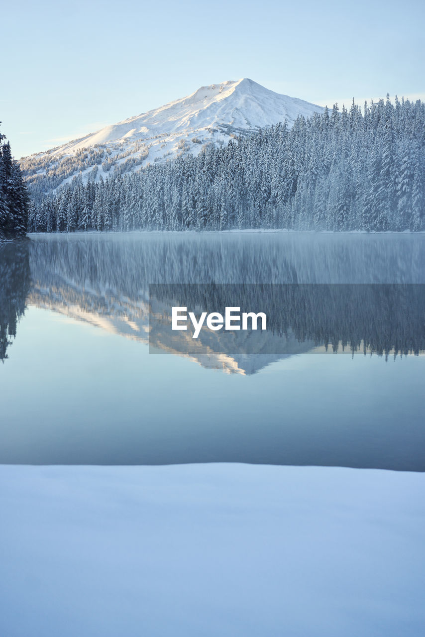 Scenic mountain in winter reflecting in lake