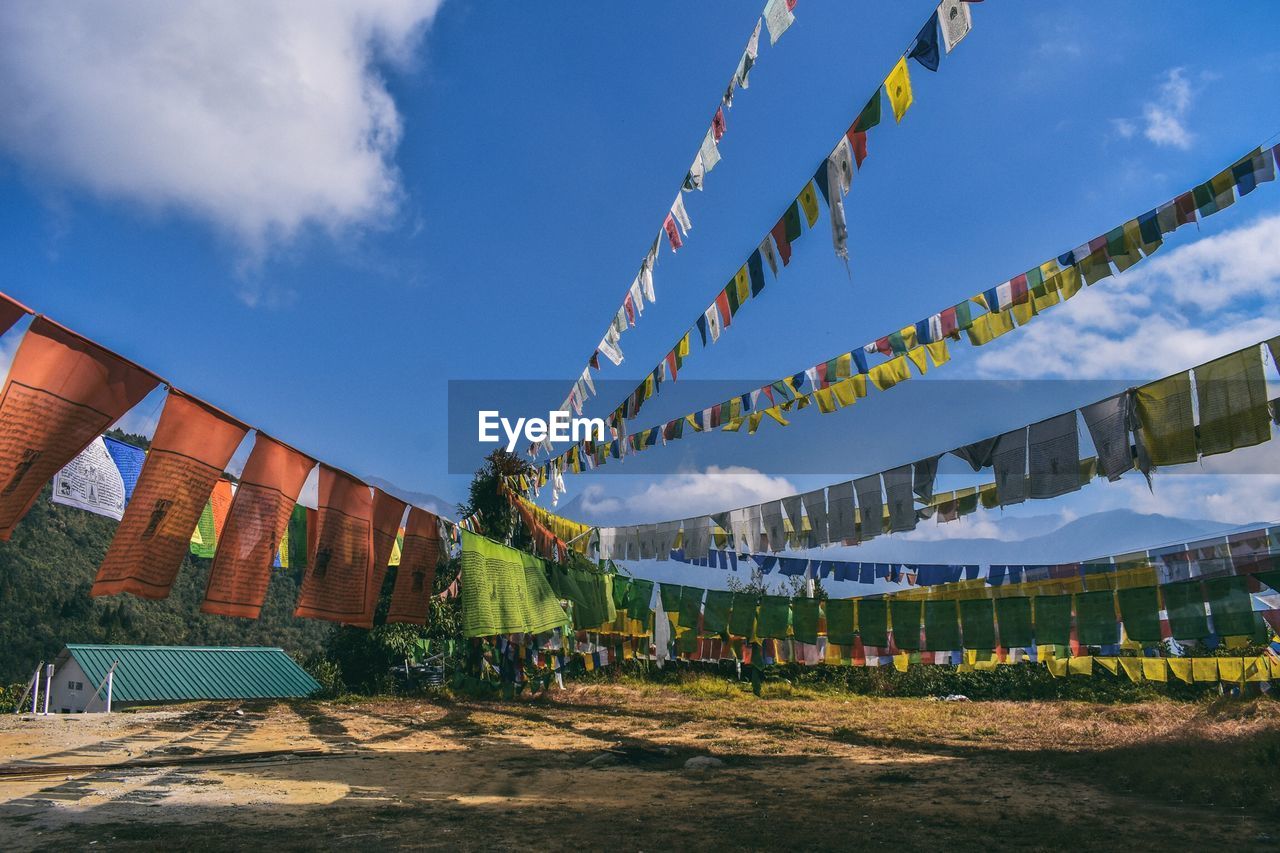 Low angle view of multi colored prayer flags against sky