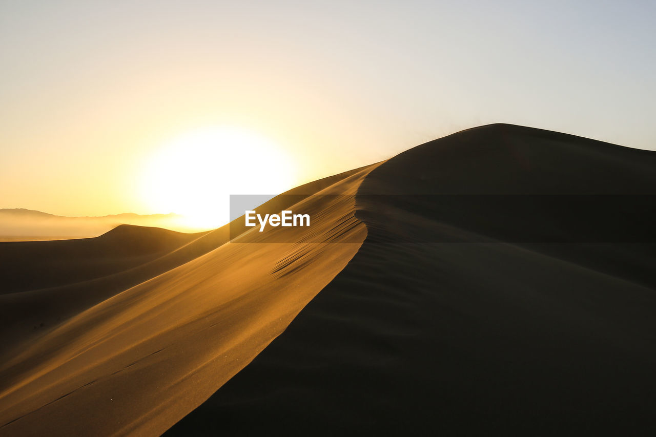 Scenic view of mountains against sky at sunset