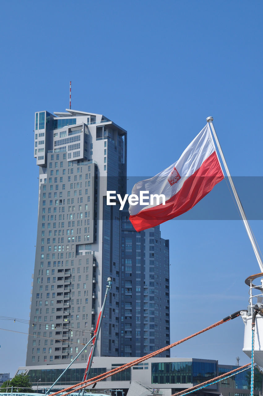 Low angle view of flag against blue sky