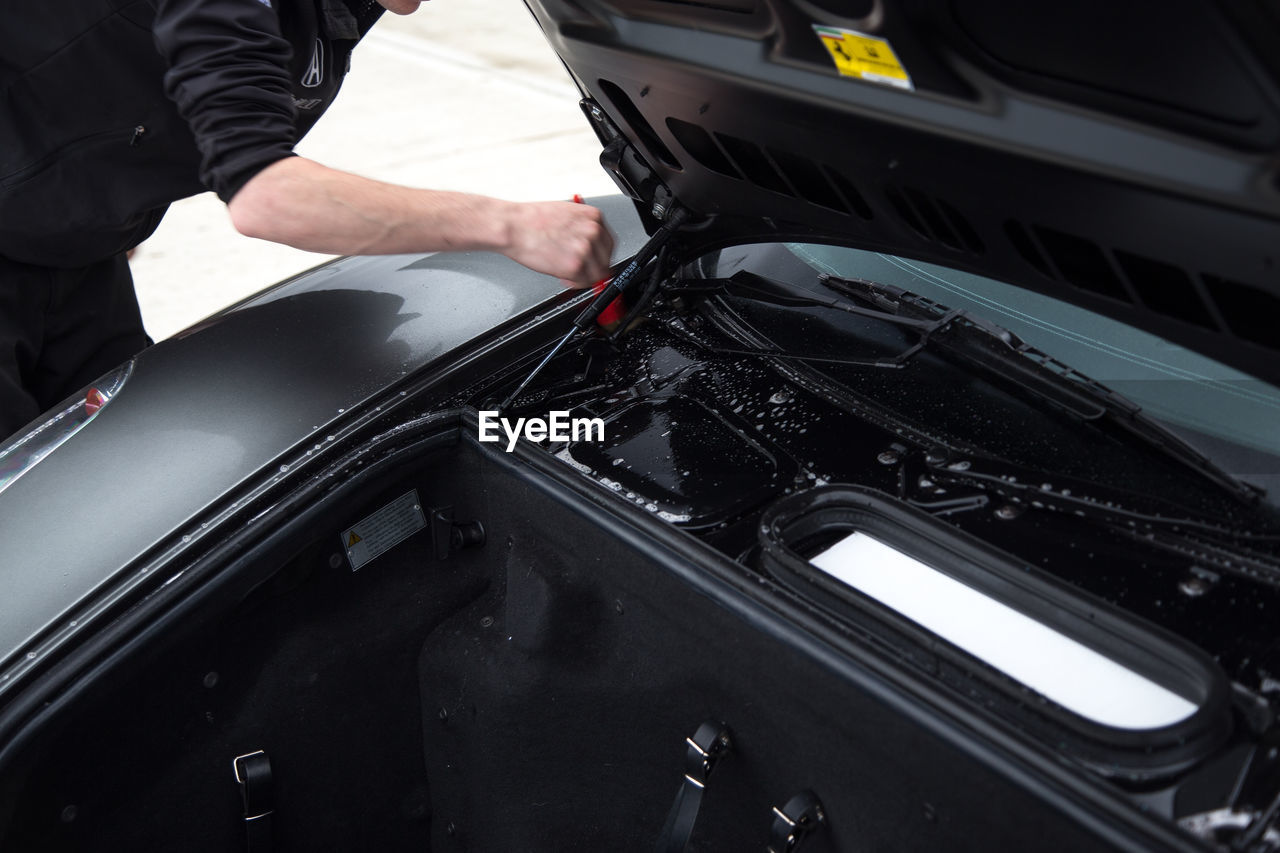 Midsection of man washing car