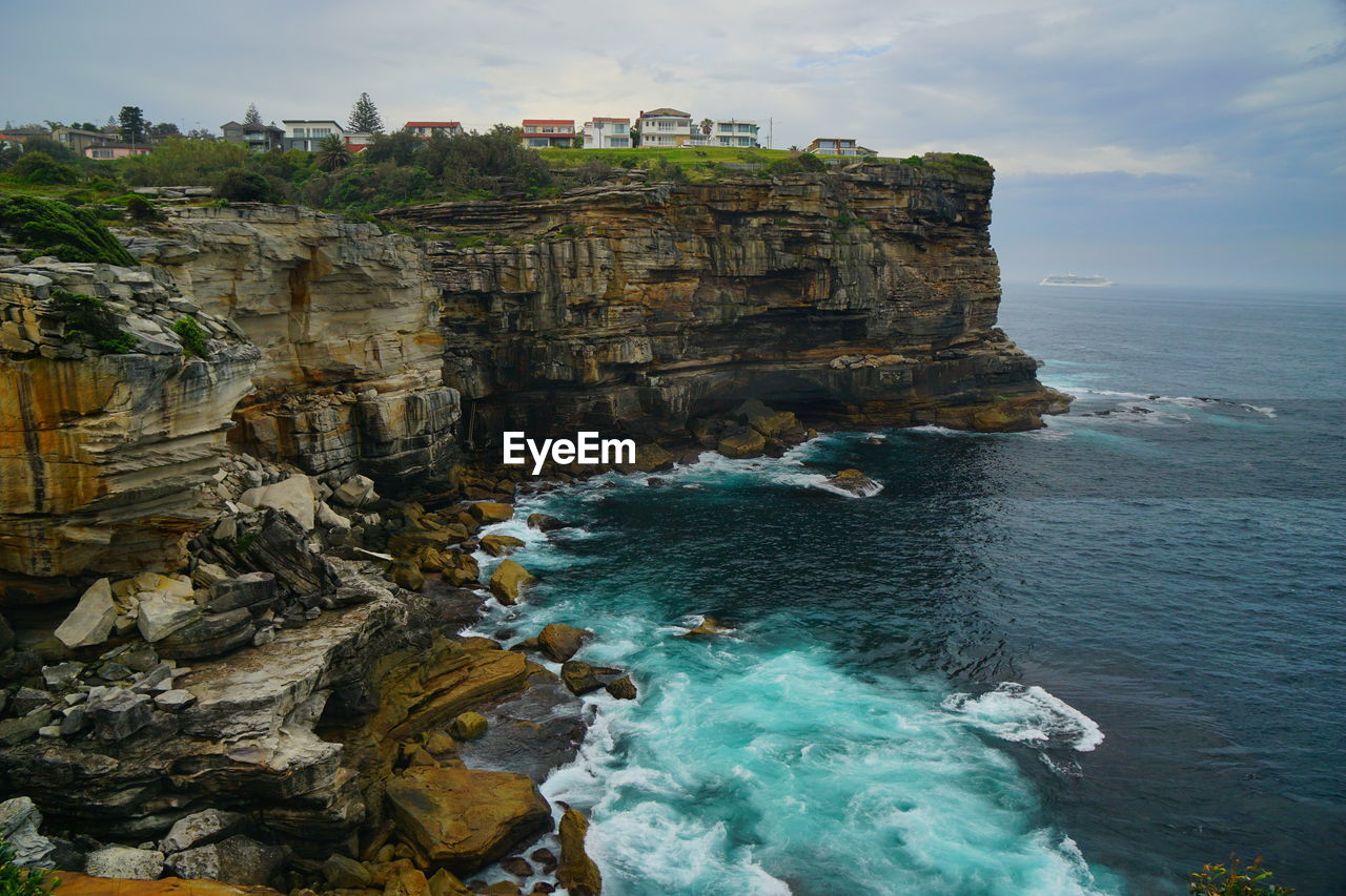 Scenic view of rocks in sea against sky