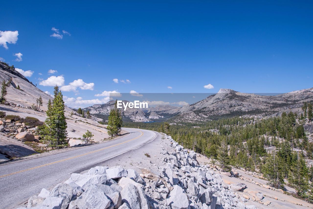 Road by mountains against blue sky