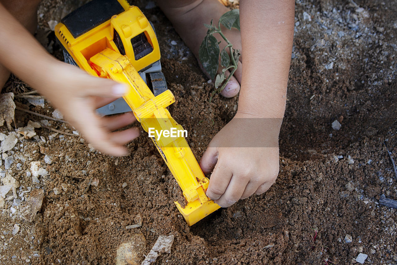 HIGH ANGLE VIEW OF HANDS WORKING AT CONSTRUCTION SITE