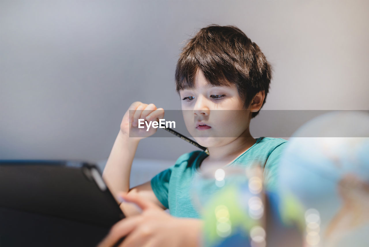 Cute boy using digital tablet at home