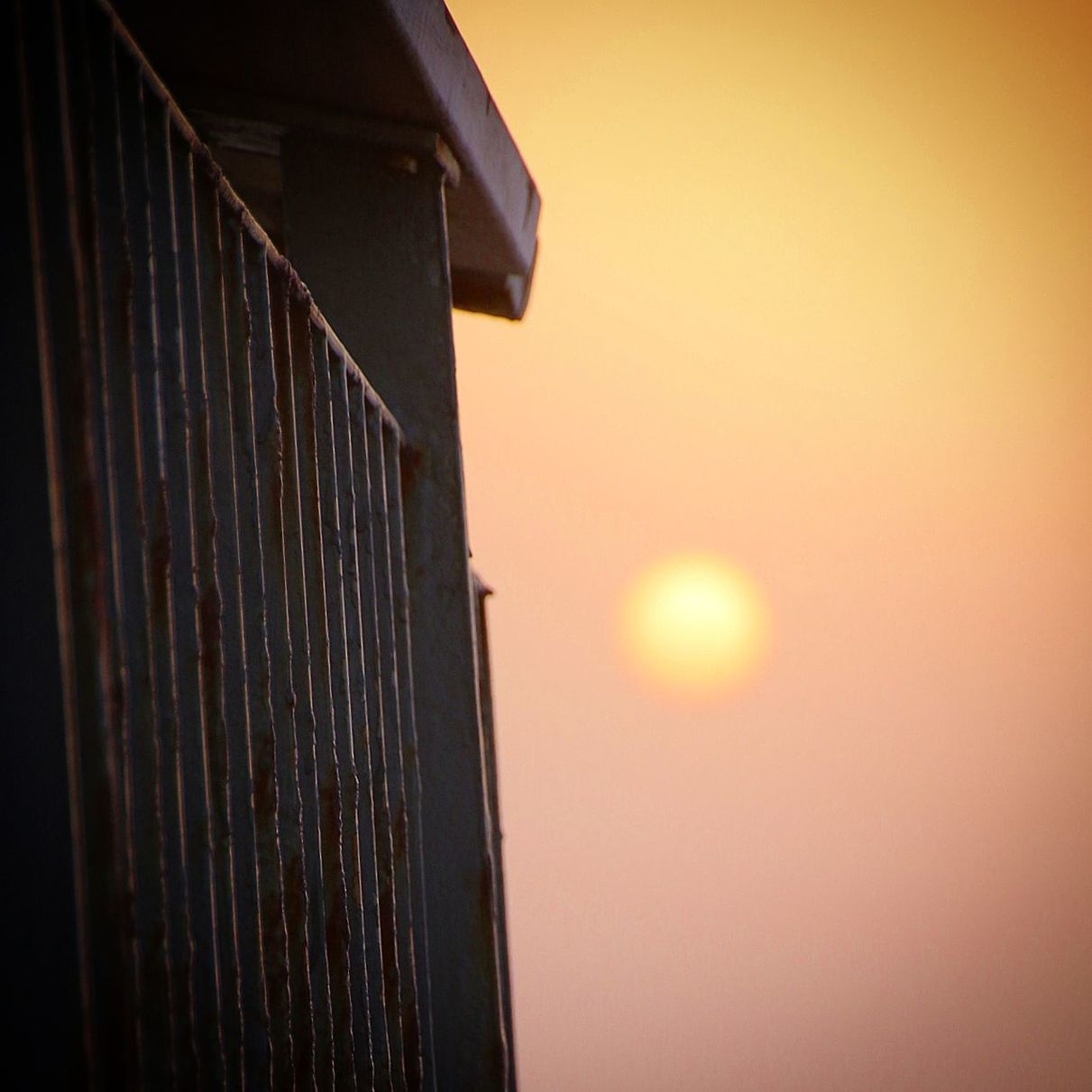 LOW ANGLE VIEW OF BUILDING AGAINST SUNSET