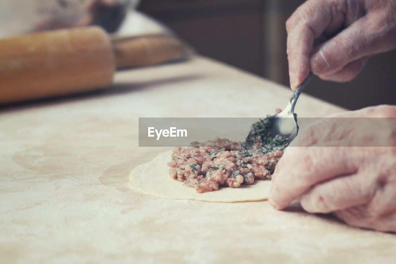 Midsection of person making dumpling