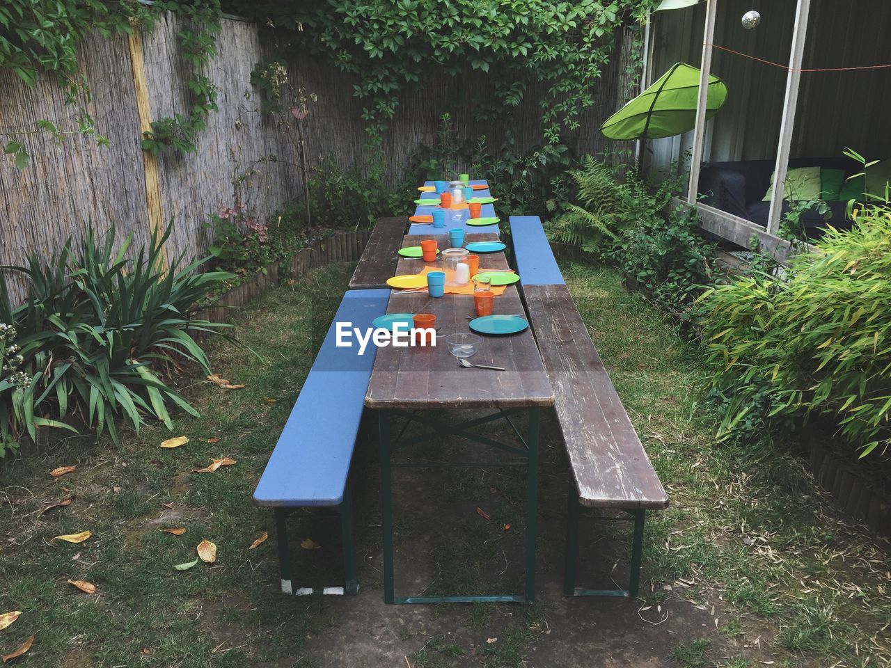 High angle view of plates and glasses on table in yard
