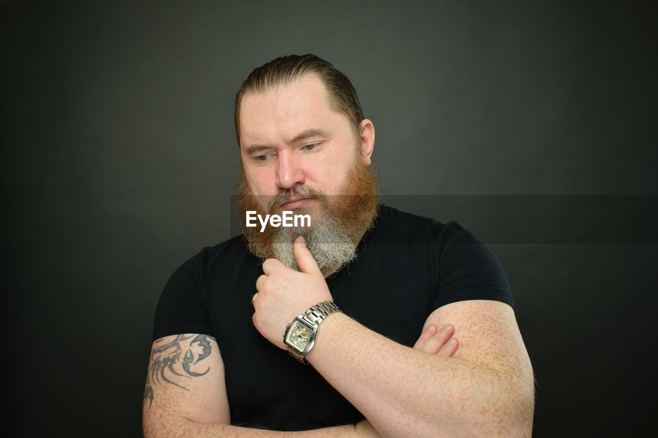 PORTRAIT OF MID ADULT MAN AGAINST BLACK BACKGROUND