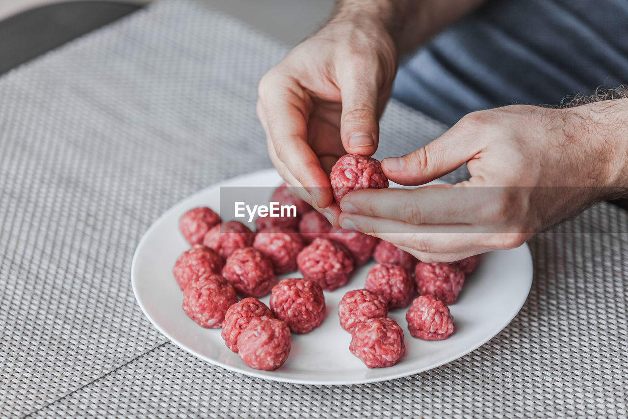 HIGH ANGLE VIEW OF PERSON HOLDING STRAWBERRIES