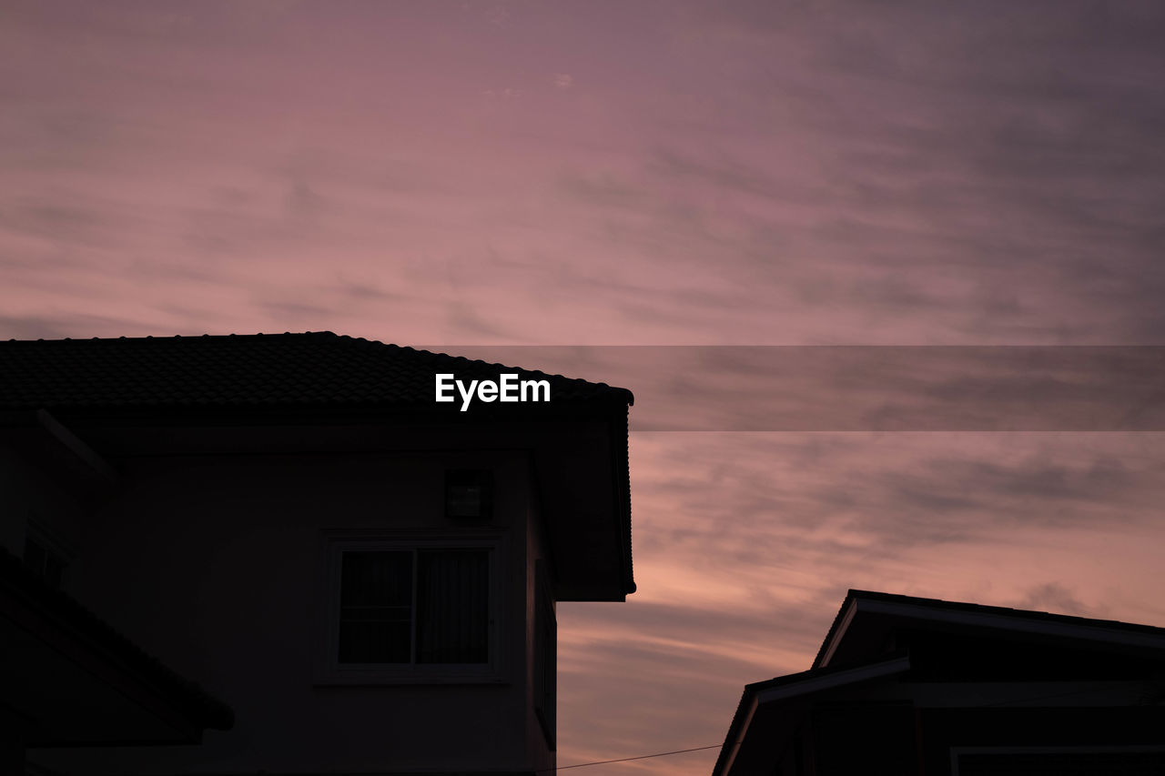 Low angle view of silhouette house against sky during sunset