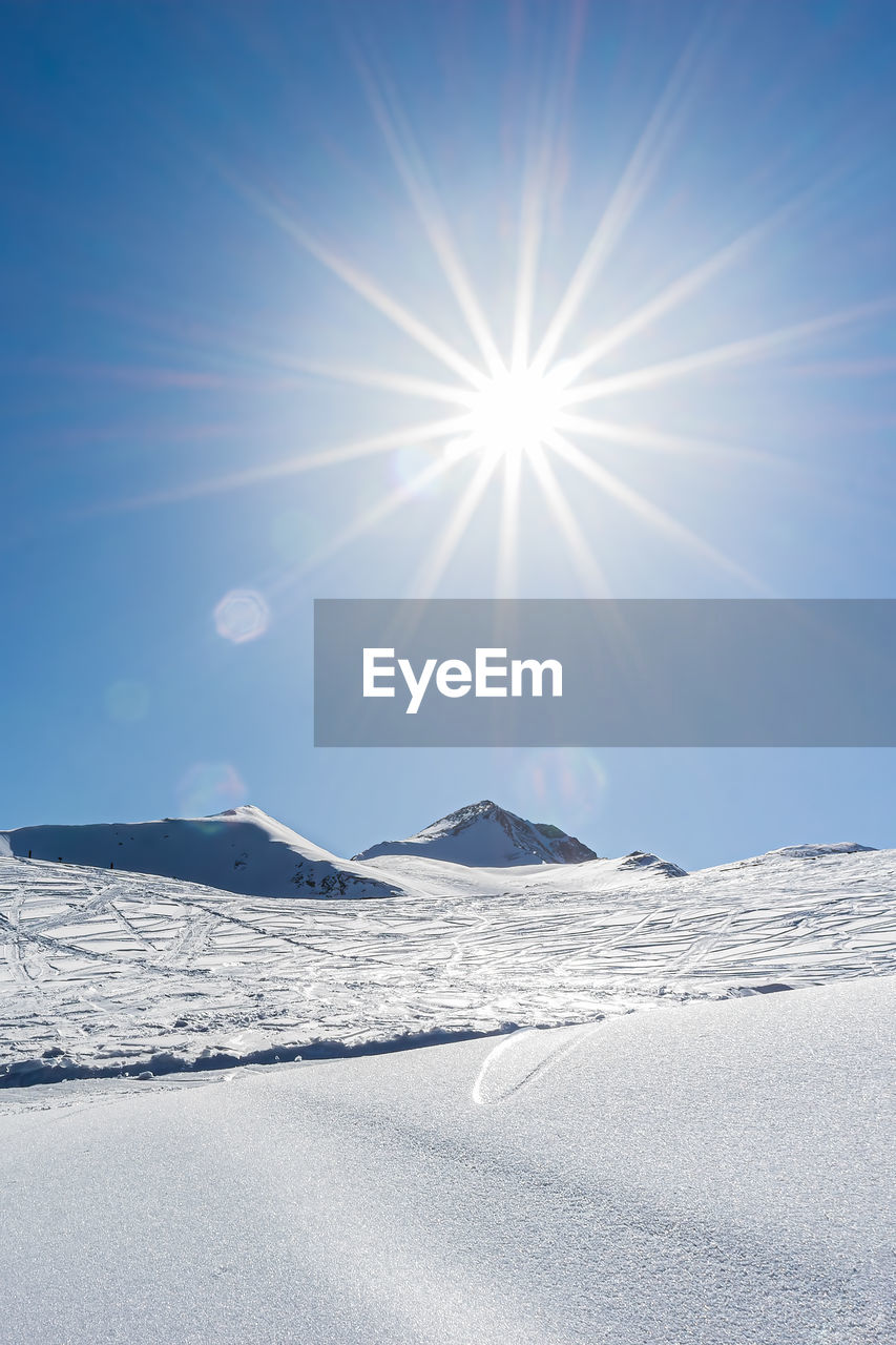 SCENIC VIEW OF SNOWCAPPED MOUNTAIN AGAINST SKY DURING SUNNY DAY