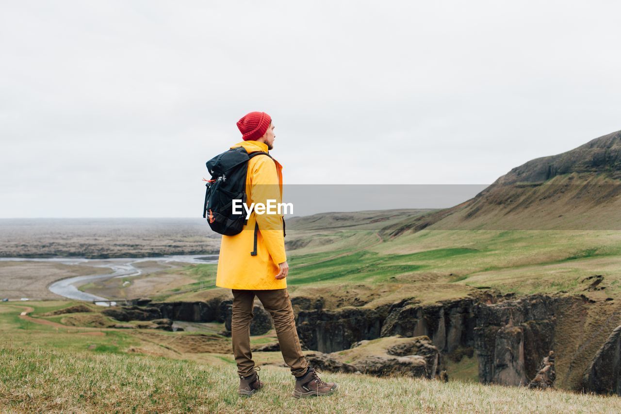 Man standing on mountain against sky