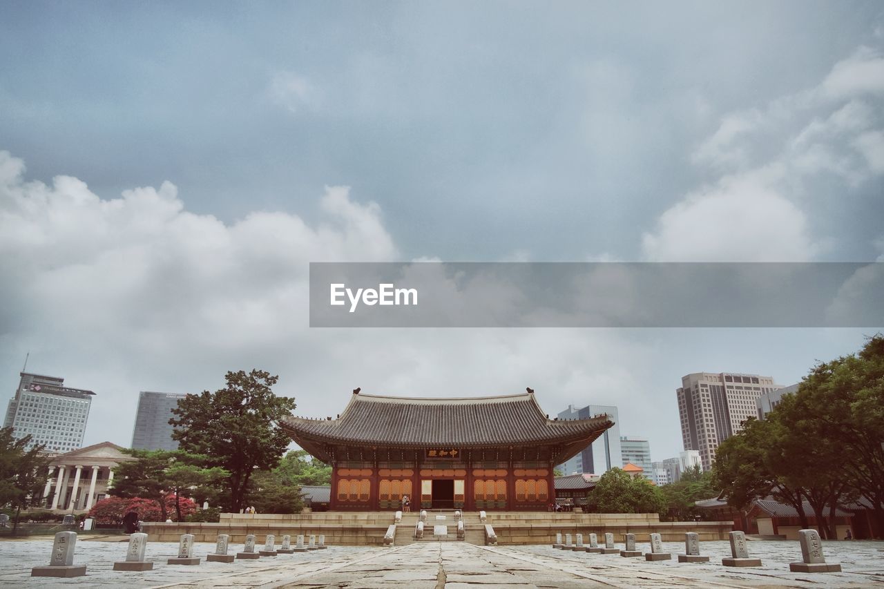 Facade of deoksugung palace against cloudy sky