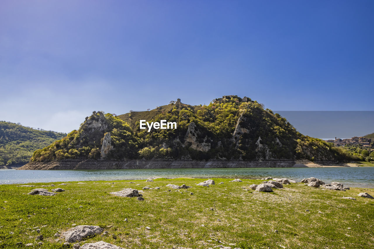 water, nature, sky, landscape, mountain, land, lake, environment, coast, scenics - nature, beauty in nature, shore, highland, wilderness, body of water, grass, plant, no people, travel destinations, travel, tranquility, rock, animal, animal wildlife, beach, mountain range, animal themes, tranquil scene, non-urban scene, outdoors, day, tourism, blue, clear sky, mammal, wildlife, coastline, bay, cloud, summer, tree, ocean, plateau, horizon, idyllic