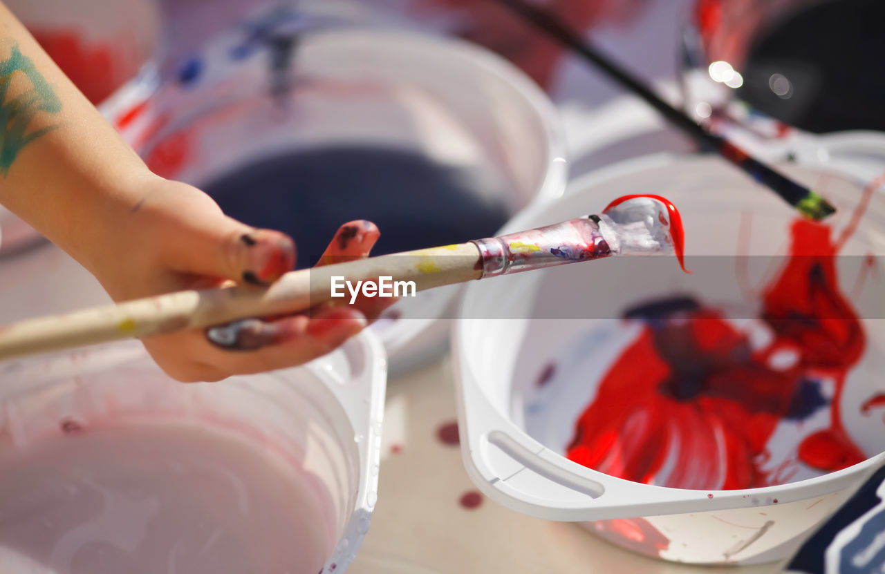 Close-up of girl hand holding paintbrush