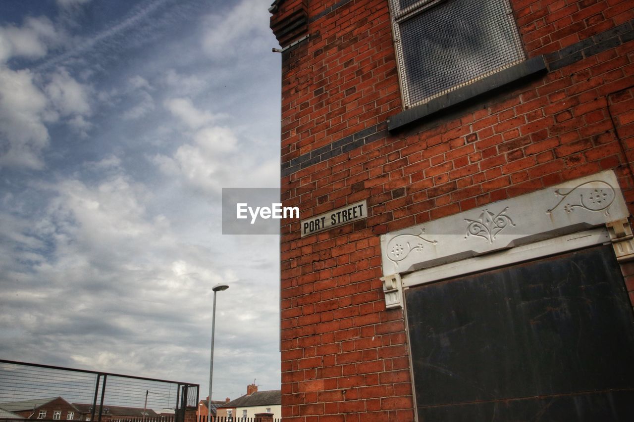 LOW ANGLE VIEW OF TEXT ON BUILDING AGAINST SKY