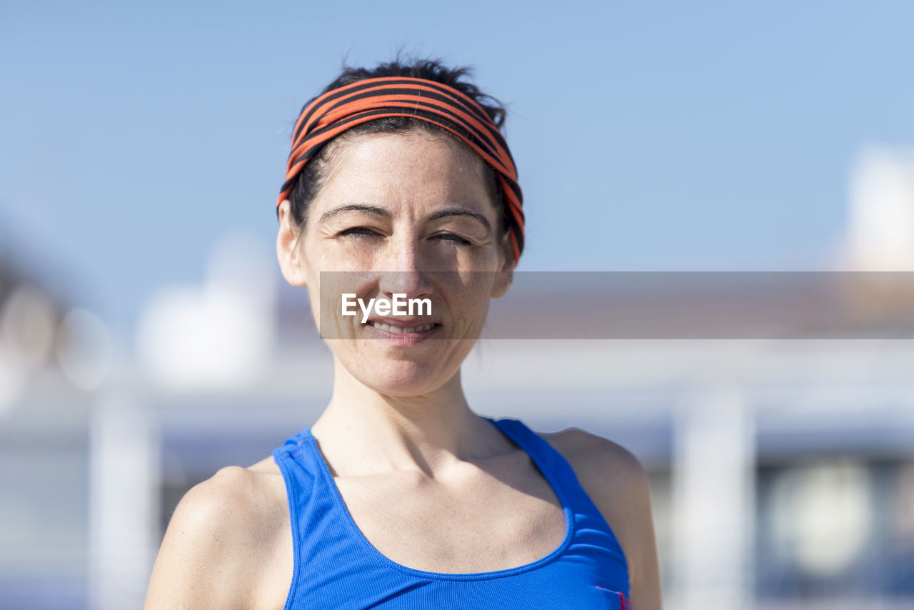 Portrait of mature woman standing against clear sky