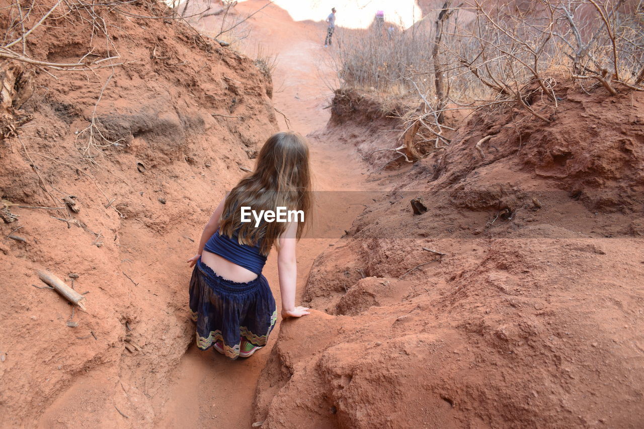 Rear view of girl standing on rock formation