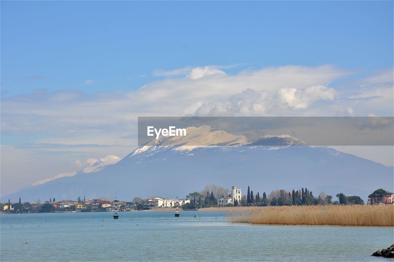 Scenic view of sea by buildings against sky