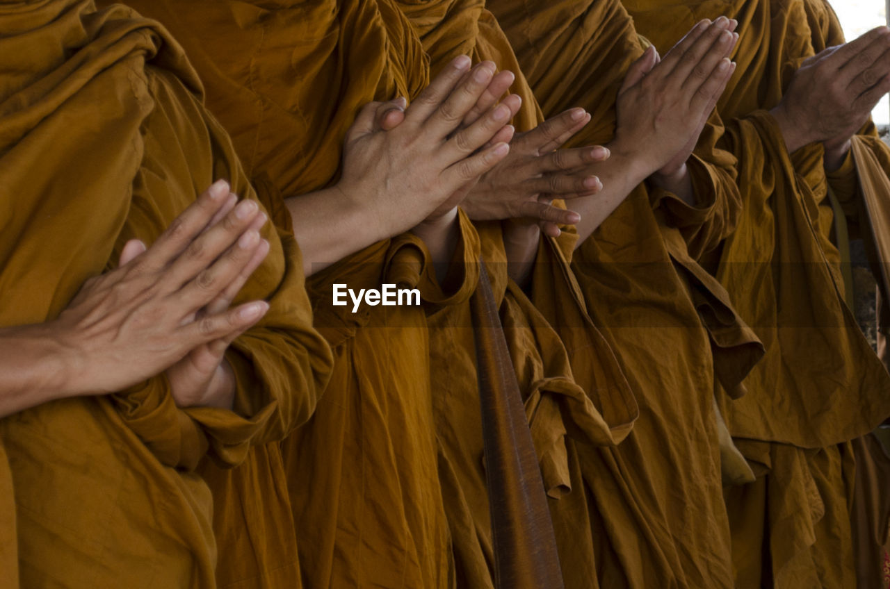 Midsection of monks praying