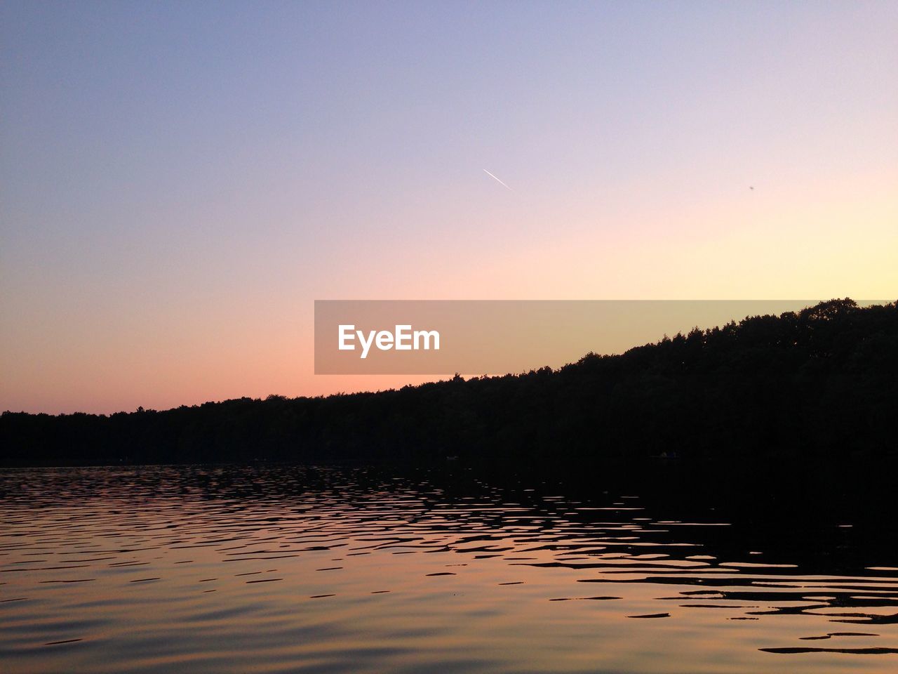 SILHOUETTE LANDSCAPE AGAINST CALM LAKE