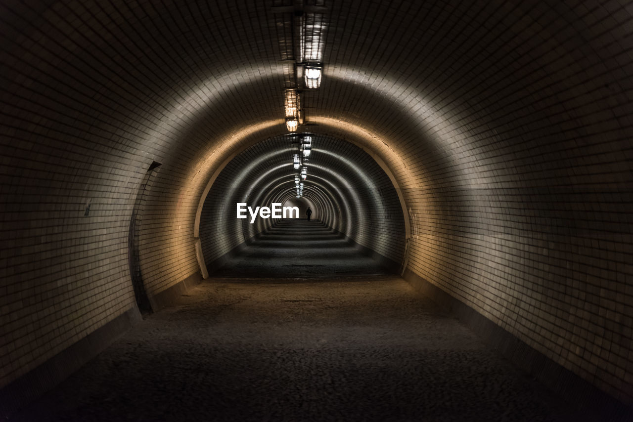 Silhouette of single pedestrian on the end of tunnel in prague