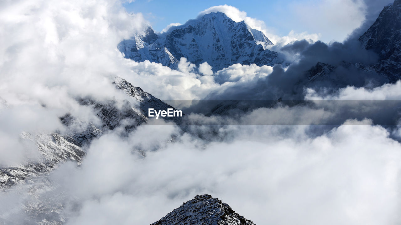 Low angle view of snowcapped mountains against sky