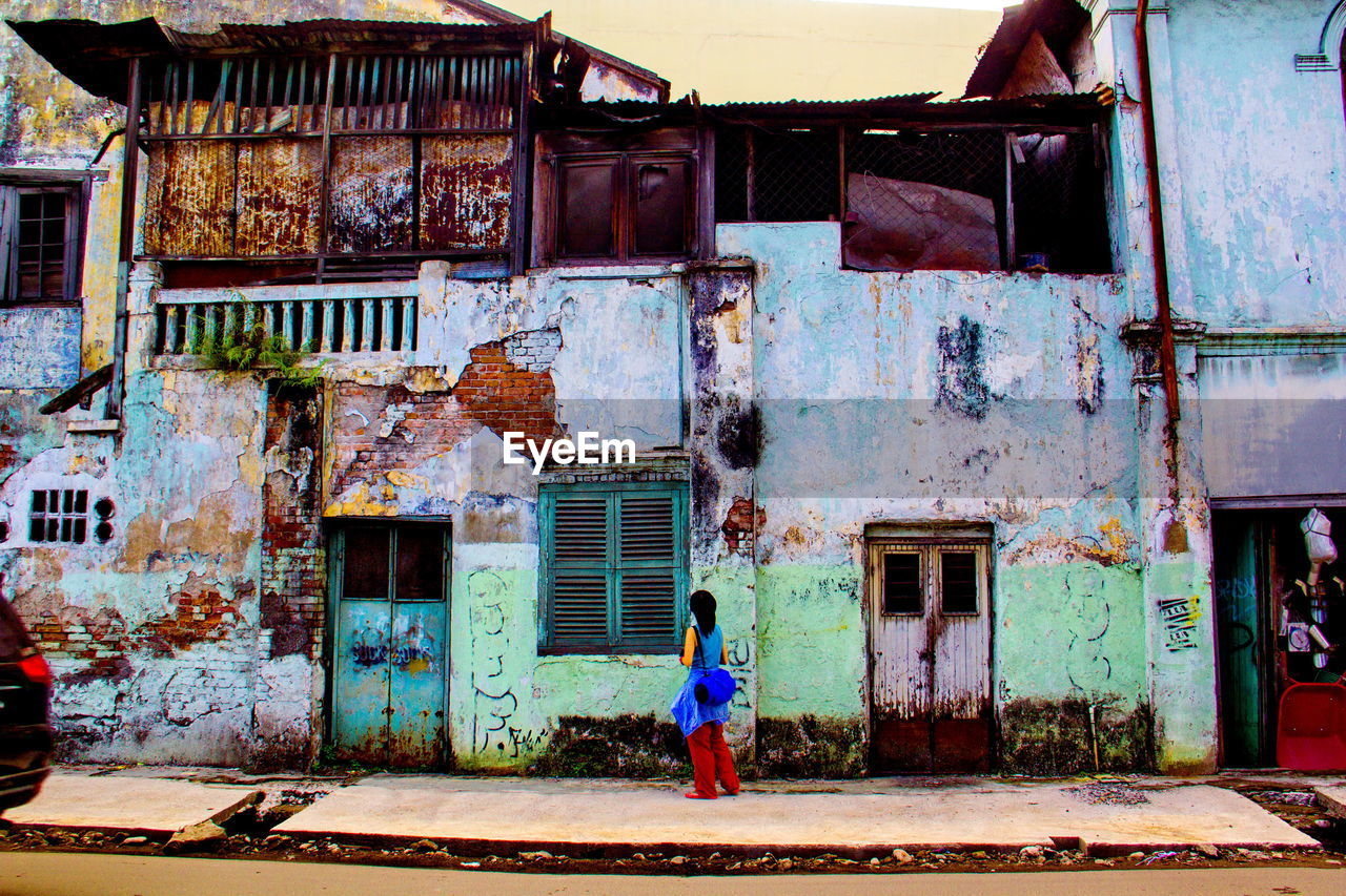 FULL LENGTH REAR VIEW OF WOMAN WALKING IN FRONT OF BUILDING