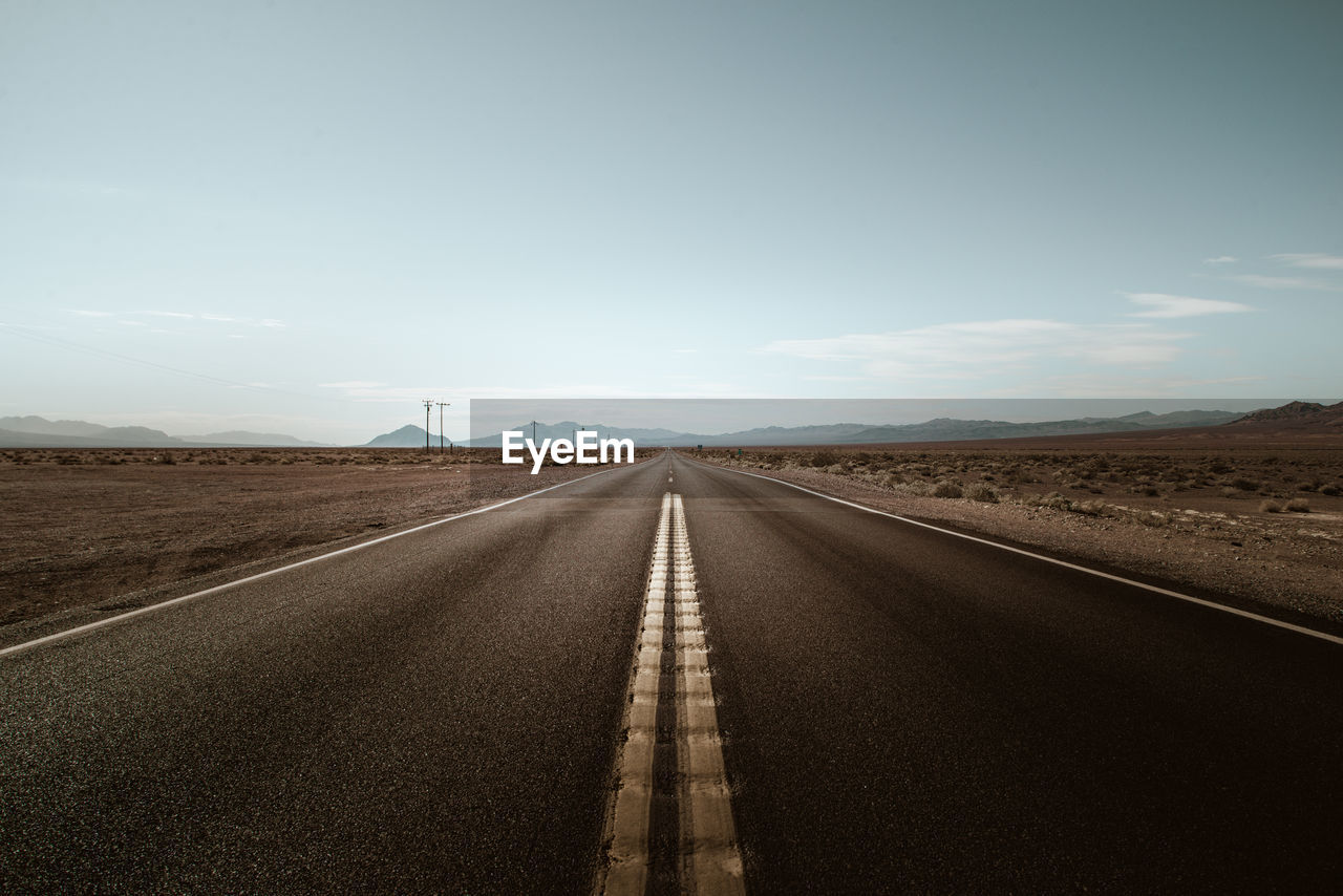 Empty road along countryside landscape