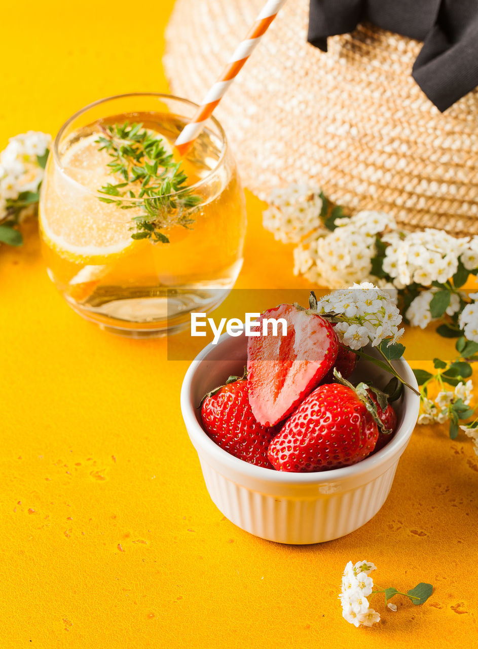 Summer background. straw hat, refreshing lemonade, ripe strawberries in a bowl. copy space.