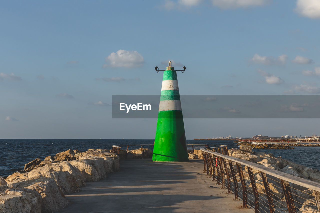 LIGHTHOUSE AMIDST SEA AGAINST SKY