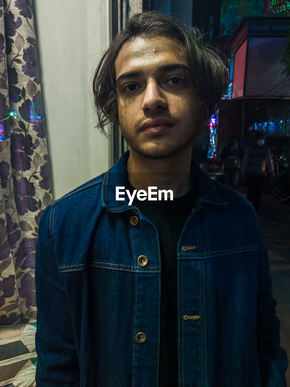 PORTRAIT OF YOUNG MAN STANDING AGAINST WALL