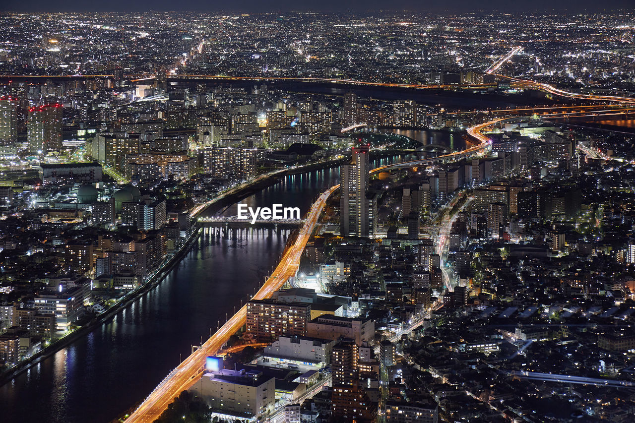 Aerial view of river passing through illuminated city at night