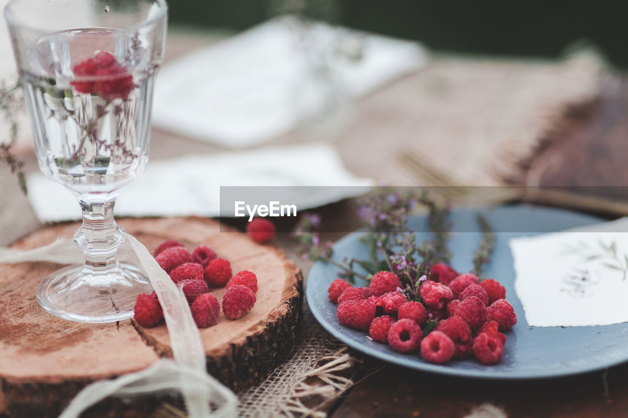 Raspberries in plate on table