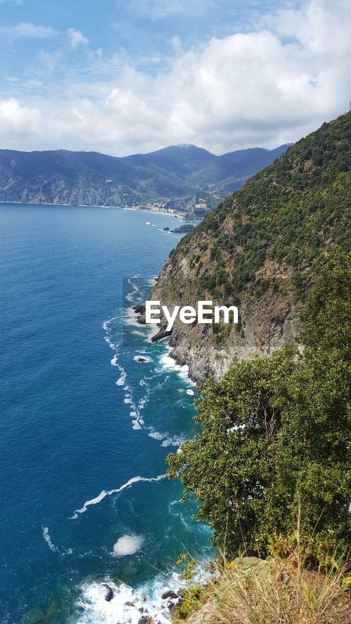 Scenic view of sea and mountains against sky