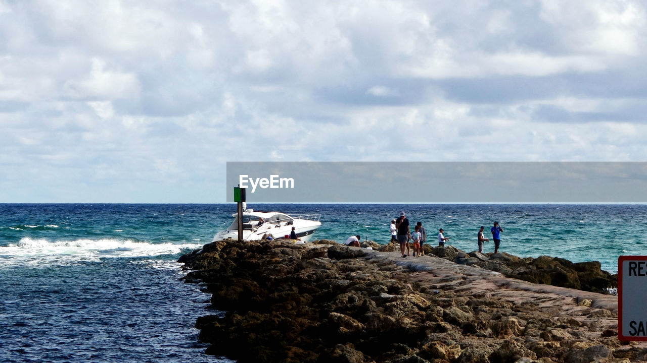 sea, water, shore, sky, ocean, horizon over water, coast, horizon, beach, land, body of water, nature, cloud, bay, vacation, group of people, day, beauty in nature, scenics - nature, wave, holiday, outdoors, trip, men, travel, rock, transportation, tower, travel destinations, tranquility, nautical vessel, sand