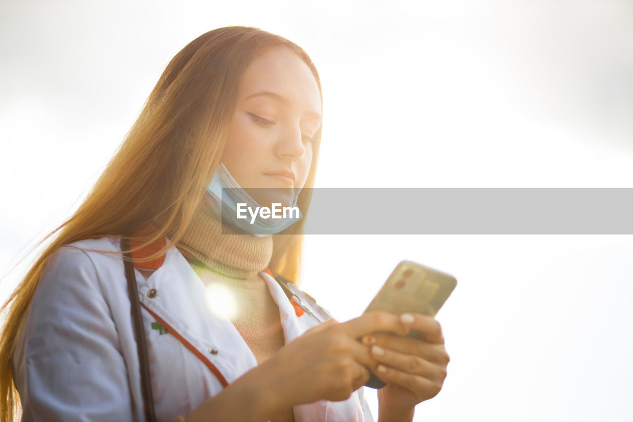 Doctor wearing mask using phone