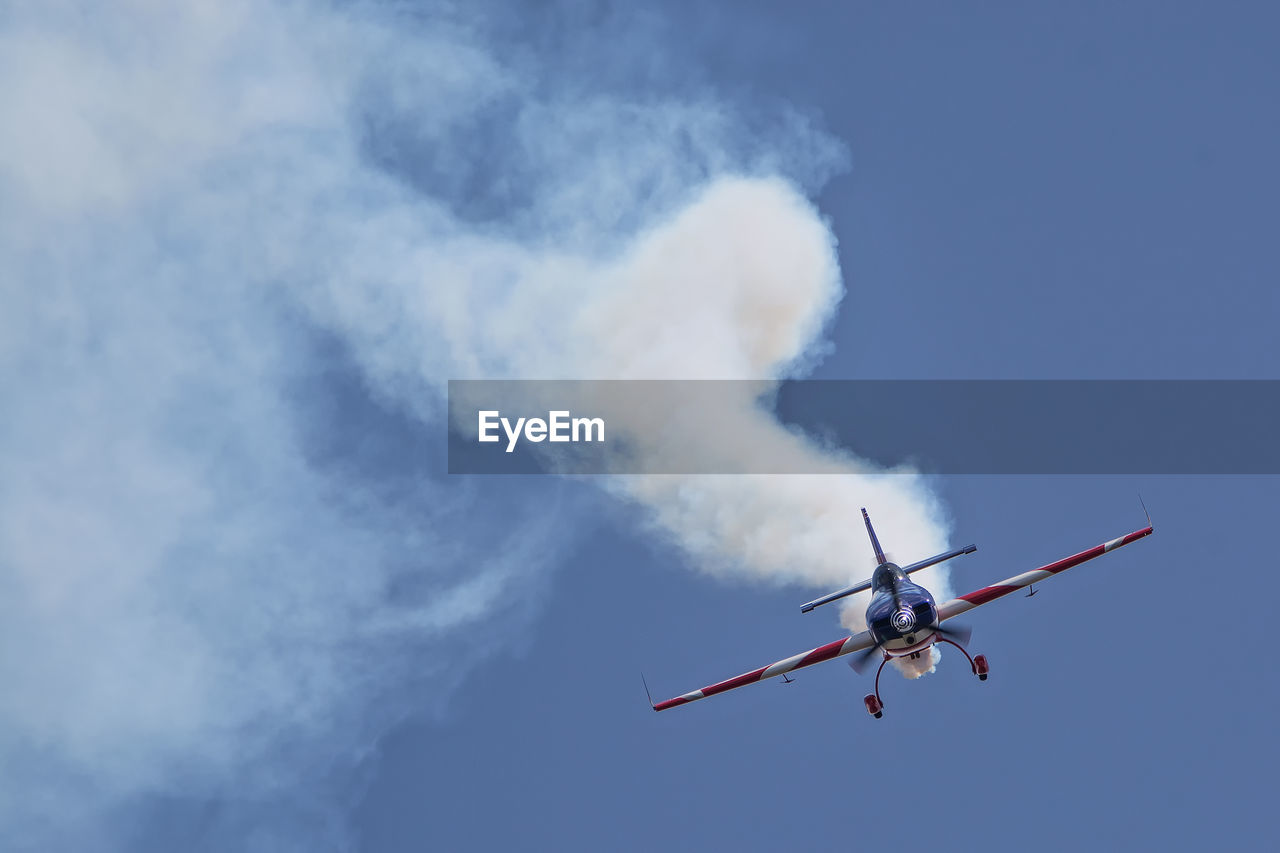 Smoke emitting from military airplane against sky