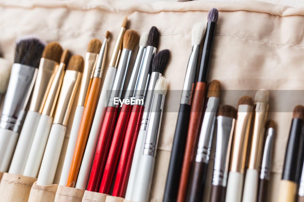 HIGH ANGLE VIEW OF PAINTBRUSHES IN CONTAINER