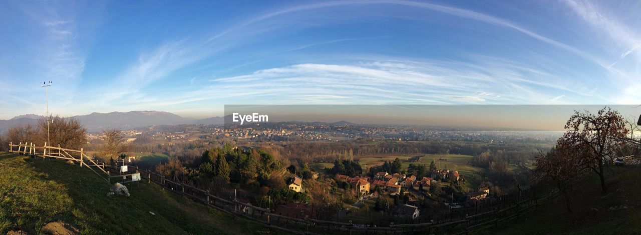 HIGH ANGLE VIEW OF TOWNSCAPE BY TREES AGAINST SKY
