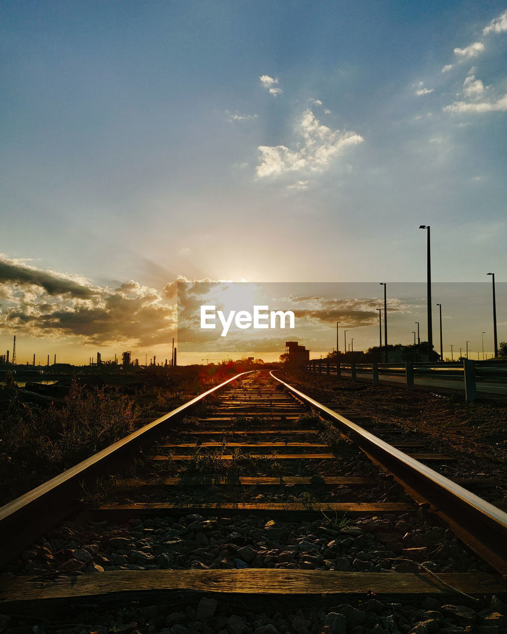 RAILROAD TRACKS AGAINST SUNSET SKY