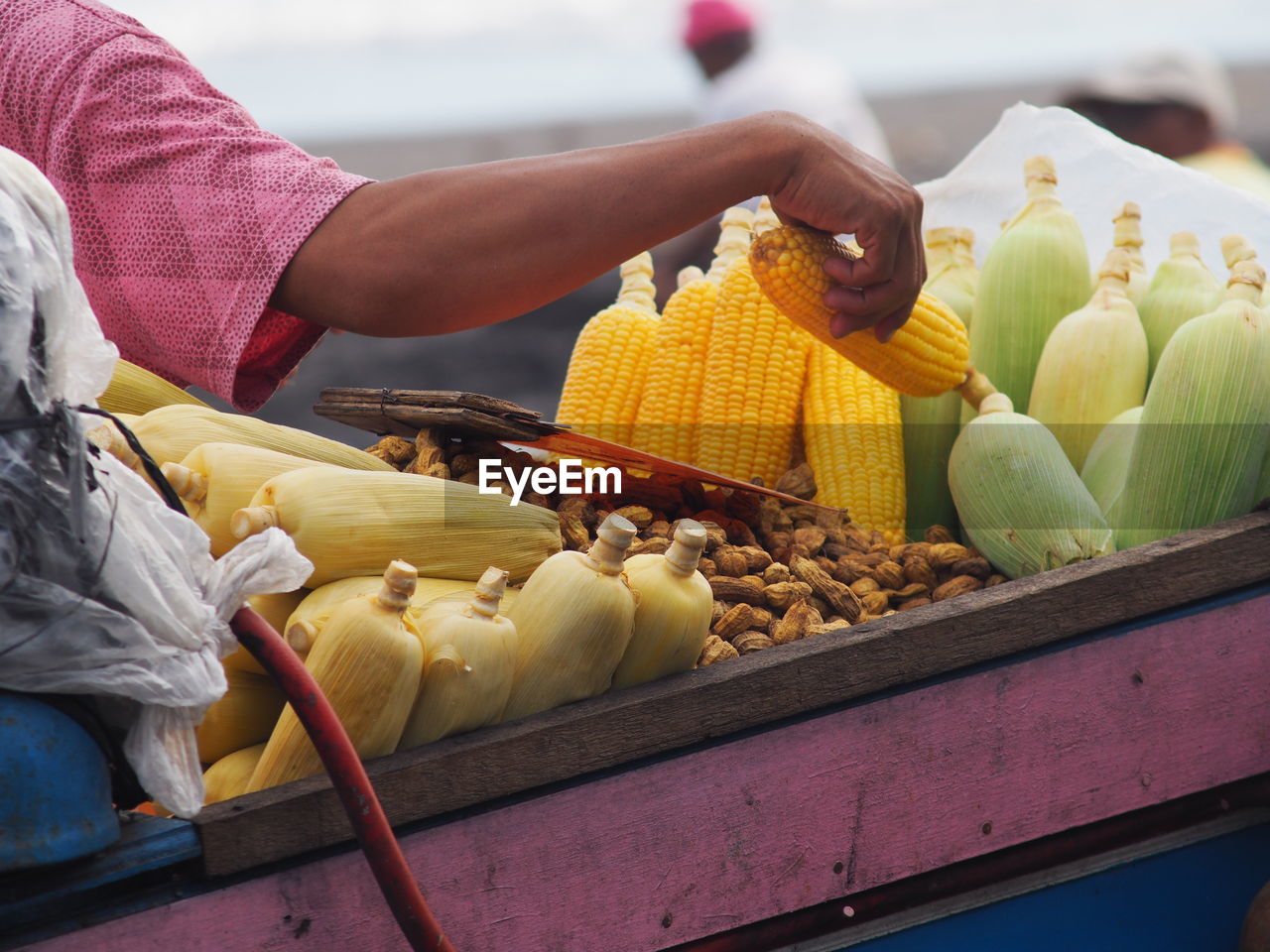 food, food and drink, healthy eating, freshness, vegetable, adult, wellbeing, one person, market, corn, fruit, produce, day, business, agriculture, retail, business finance and industry, sweet corn, hand, occupation, city, market stall, yellow, outdoors, holding, organic, women, flower, rural scene, men, selling, nature, abundance, variation, public space, lifestyles, crop, vendor, small business, casual clothing, harvesting, midsection