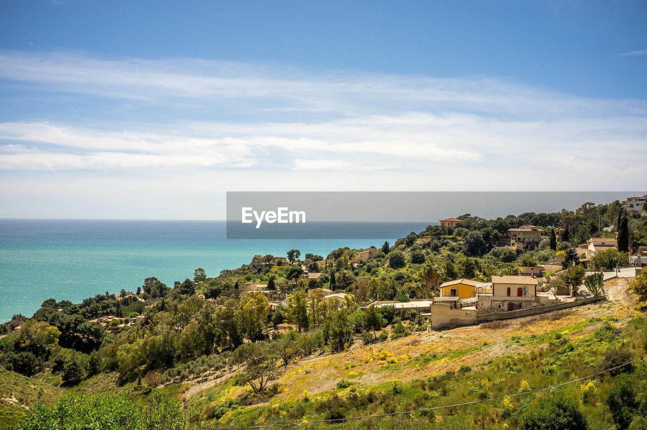 sea, sky, water, land, coast, nature, scenics - nature, vacation, architecture, horizon, plant, horizon over water, beach, ocean, beauty in nature, cloud, shore, landscape, travel destinations, building, building exterior, built structure, hill, travel, environment, cliff, no people, tree, tranquility, coastline, tourism, outdoors, tranquil scene, day, rock, city, terrain, bay, blue, body of water, holiday, house, trip, idyllic, history, urban skyline, residential district