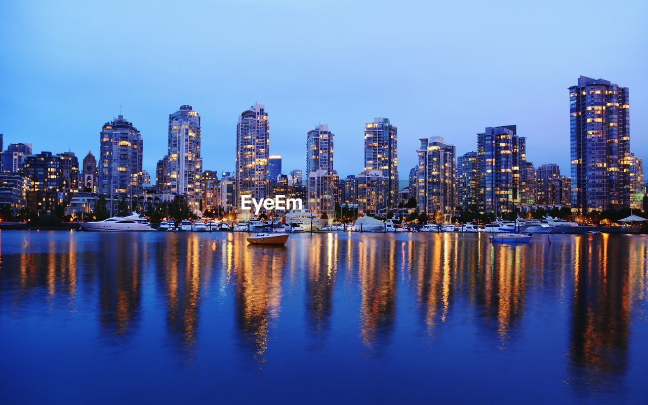 Reflection of buildings in city at waterfront