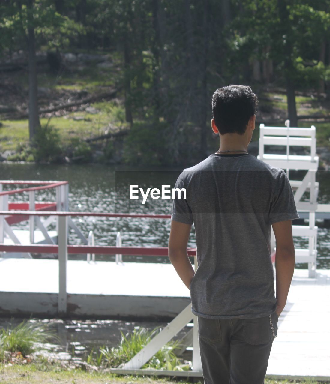 Rear view of man sitting on railing