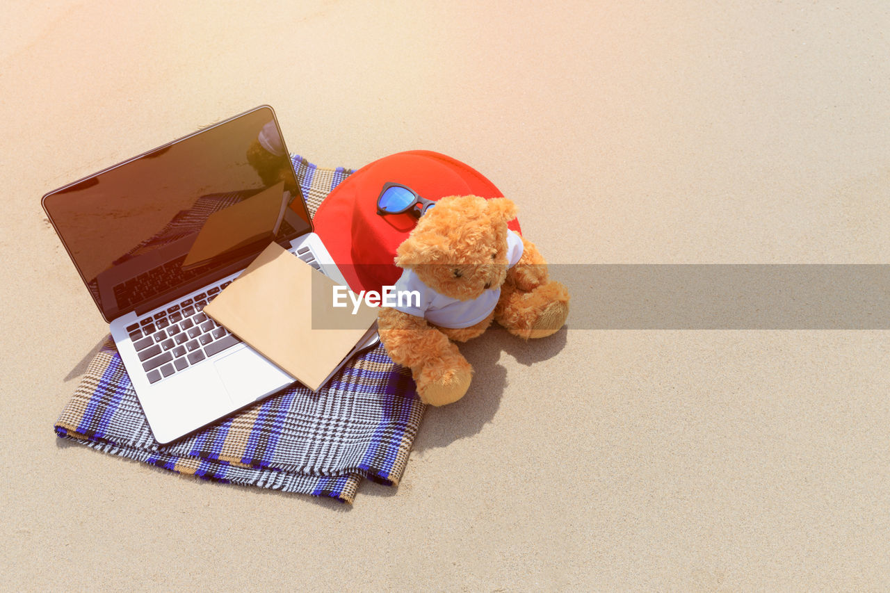 HIGH ANGLE VIEW OF STUFFED TOY ON TABLE AGAINST WHITE BACKGROUND