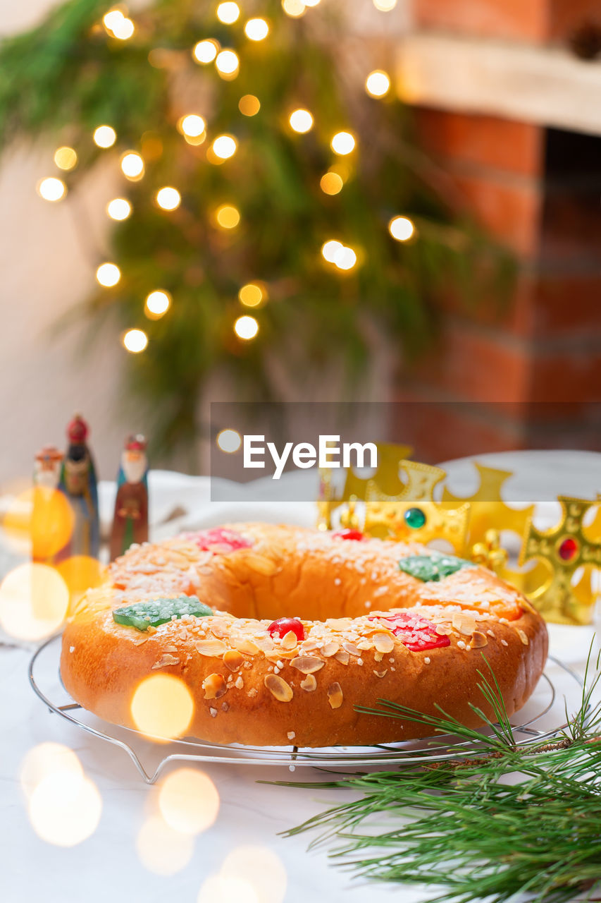 CLOSE-UP OF CAKE ON TABLE AGAINST CHRISTMAS LIGHTS