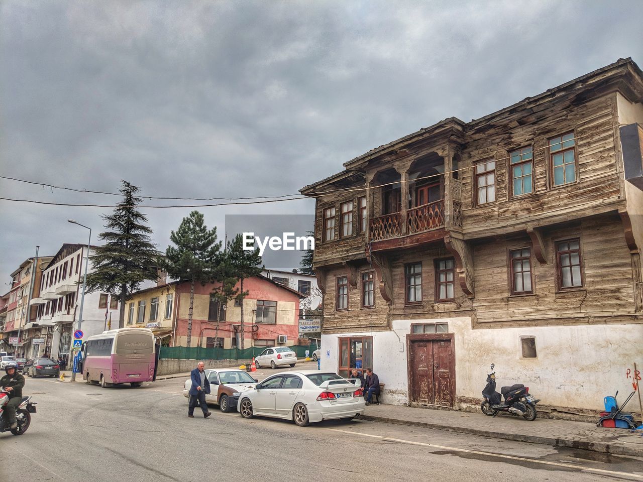 VEHICLES ON ROAD BY BUILDINGS AGAINST SKY